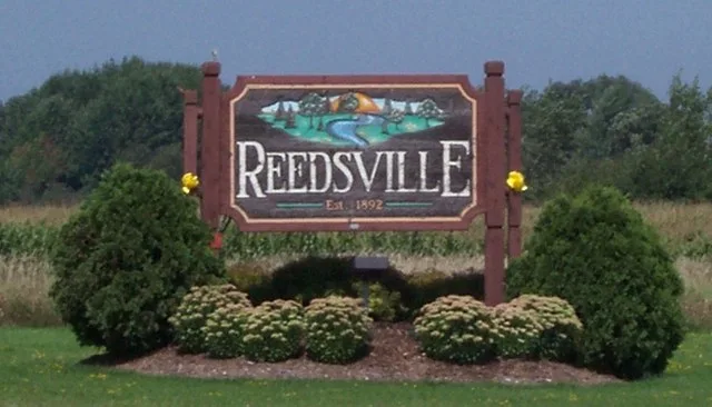 Looking northwest at the sign for en:Reedsville, Wisconsin , USA while traveling on en:U.S. Route 10 .